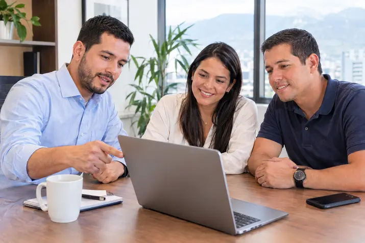 Asesor comparando opciones de seguro con una pareja en el computador